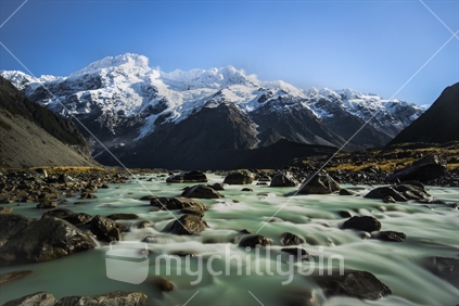 Mt Tasman in the background with Glacial snow and river outflow in foreground
