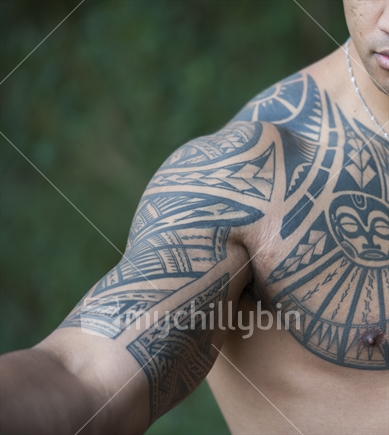 Closeup of a tribal tattooed right forearm and shoulder