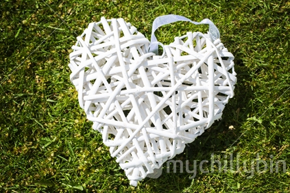 White wooden heart decoration on grass