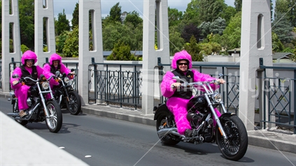 Bikers in bright pink costumes drive their motorbikes over Fairfield bridge