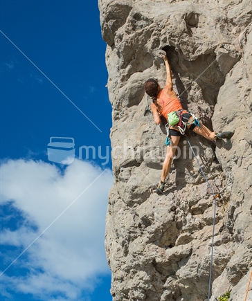 A woman displays the strength required to negotiate the rock climb on the face of Mt Maunganui in the BOP 