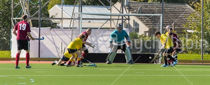 A goal is scored - male adult hockey player about to hit the ball into the goal (some motion blur)