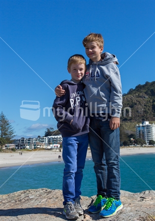 2 brothers happy to be visiting Moturiki island with Mt Maunganui's marine parade in the background.
