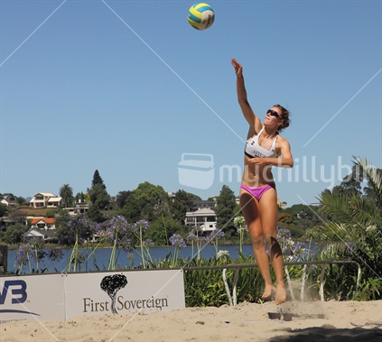 Local player jumps high to serve in the Hamilton beach Volleyball open tournament