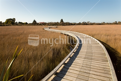 The curving boardwalk across the wetlands leading to the Okarito trig walk