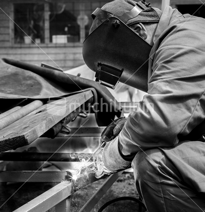 Black and white image of a man welding