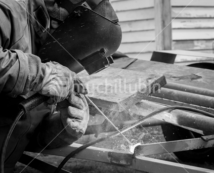 Black and white image of a man welding