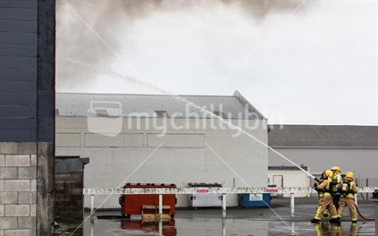 Firefighters attack the fire from the rear of the building