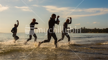 Athletes start to transition from the swim leg as they exit the water at Takapuna beach