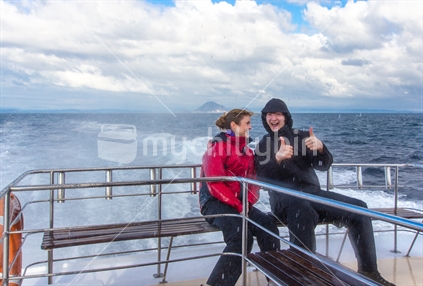 Man & woman enjoying the sea spray on boat trip