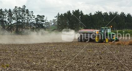 Tractor spreading fertiliser in a paddock