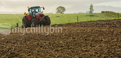 Early start for a farmer ploughing a field
