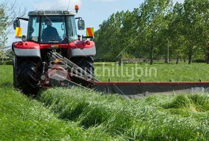 Tractor with mower arm cutting grass