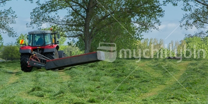 Tractor in paddock with mowing attachment raised