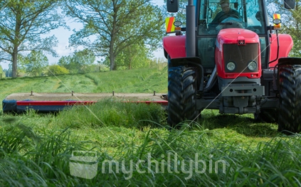 Closeup of tractor using mowing attachment