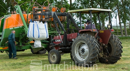 Tractor prepares to tip fertiliser into the maize planter