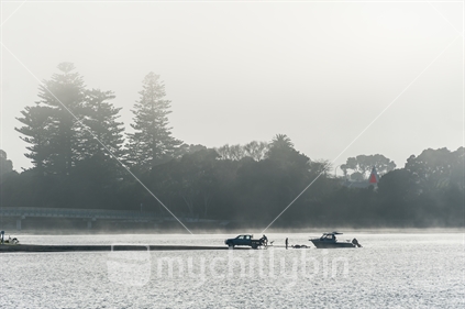 Launching a fishing boat on a foggy Raglan morning. (focus distant)