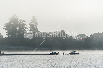 A boat launching on Raglan harbour, on a foggy morning.
