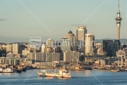 Cargo ship berthing at Auckland port with city backdrop