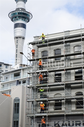 Riggers passing up brackets to scaffold on old building in Auckland, as 