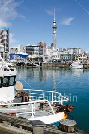 Fishing trawler with Auckland CBD skyline.