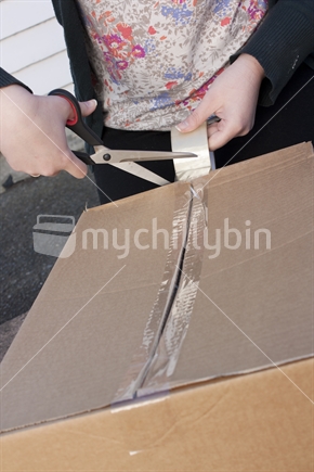 Person packing a box in preparation for moving house.  