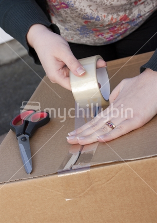 Person packing a box in preparation for moving house.  