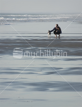 Woman with dog on beach.  