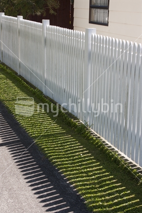 Picket fence casting a shadow.  