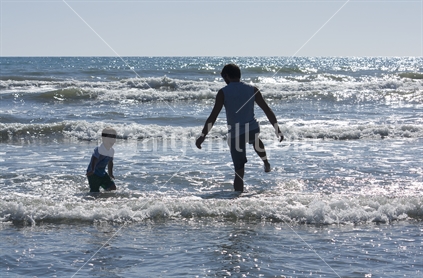 Father and son playing in the waves at beach
