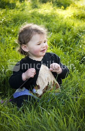 Sweet little girl sitting in the grass