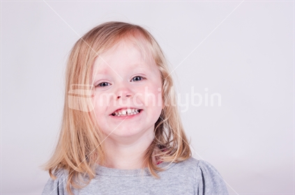 Smiling toddler girl on simple background