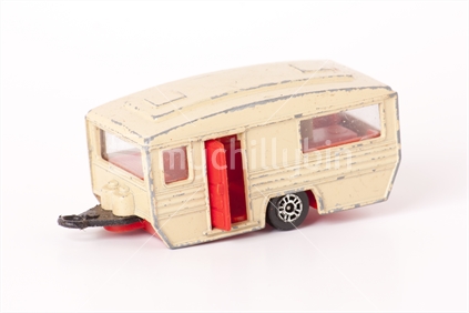 Old and dirty small toy caravan from the 60's isolated on a white background.  