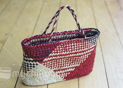 A multi-coloured kete woven from Harakeke flax