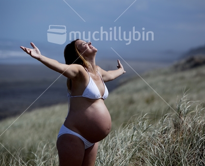 A pregnant woman, enjoying the sun at the beach