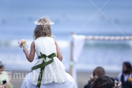 Flower girl, at an outdoor wedding at the beach.