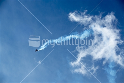 Biplane in the sky with vapor trails