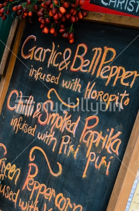A salami menu on a chalkboard at a rural market.