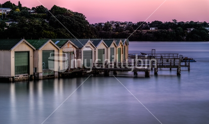 Boatsheds in the Orakei Basin at just after sunset.