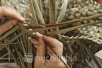 Making a potae (hat), closeup with hands - Maori flax weaving 