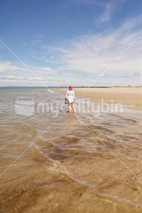 Woman standing in the water at the Houhora Heads' East Beach on Northland's Aupouri Peninsula