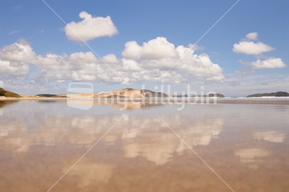 Magic mirror reflections in the sand of remote and beautiful Te Werahi Beach in the Far North
