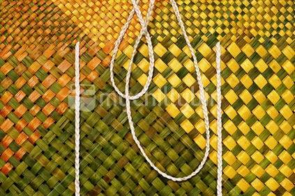 Kete, flax weaving - detailed closeup of a yellow woven kete with white muka fibre handles