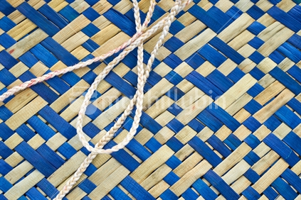 Flax weaving - detailed closeup of a blue natural woven kete with white muka fibre handles