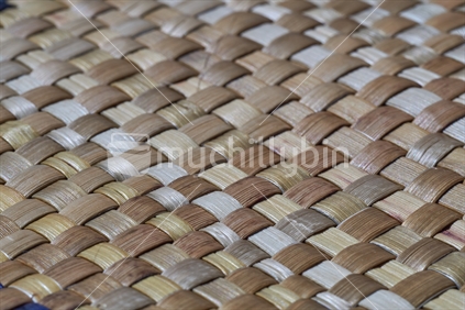 Closeup of Maori flax weaving - takitahi weave with natural colour seen sideways at an angle 