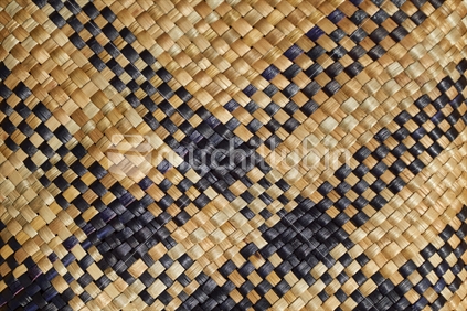 Maori flax weaving - closeup of a mat with black and natural strands (whenu)