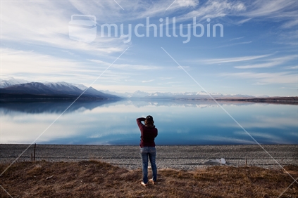 Girl photographing reflections on Lake Pukaki