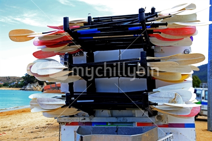 Paddles for kayaks are stacked on a trailer waiting to be transported at Kaiteriteri.
