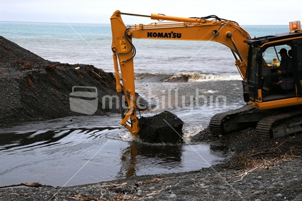 A digger clears a channel to drain water at Kaikoura.