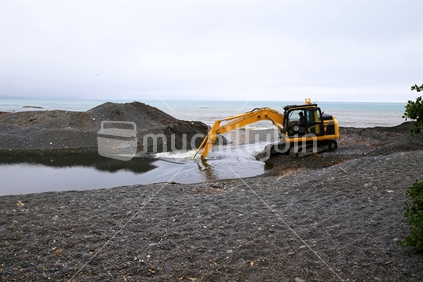 A digger clearing a channel to drain water at Kaikoura.